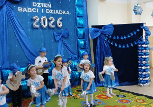 Chłopcy i dziewczynki podczas tańca z gitarami i pomponami.