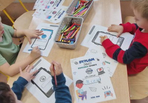 Dzieci kolorują karty pracy