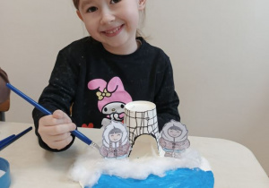 Dziewczynka prezentuje wykonaną zimową krainę Inuitów.