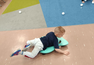 Dziecko na jeździku łapie kule