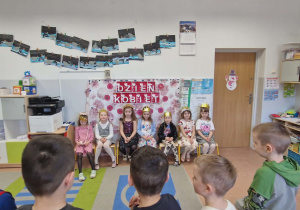 Chłopcy stoją przed dziewczynami i śpiewają im Sto lat