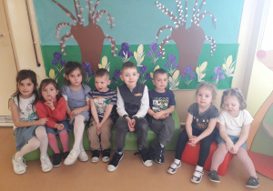 Dzieci pozują na tle wiosennego kącika.