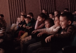 Dzieci siedzą na widowni teatru.