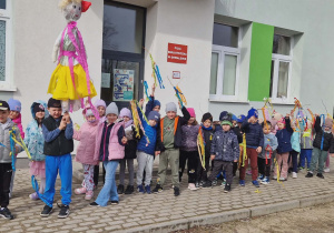 Dzieci w grupie na dworze trzymają gaiki.