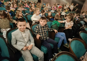Dzieci siedzą w teatrze i czekają na przedstawienie