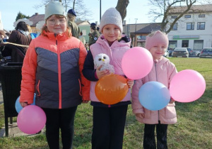 Dziewczynki z balonami podczas marszu ulicami Poddębic.