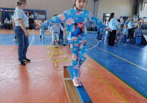 Dziewczynka przechodzi po ławce.