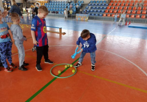 Chłopiec przenosi piłki z obręczy.