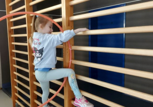 Dziewczynka wspina się po drabinkach.