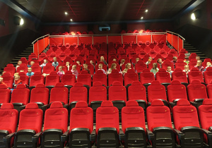 Dzieci siedzą na fotelach w kinie