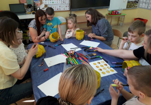 Warsztaty ekologiczne. Mamy i dzieci podczas ozdabiania doniczek z plastikowych butelek.