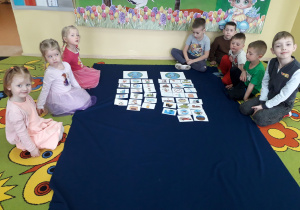 Dzieci podczas zabawy dydaktycznej na dywanie określają dobre i złe zachowania dla Ziemi.