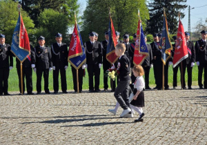 Przedszkolaki maszerują z kwiatami pod Obelisk.
