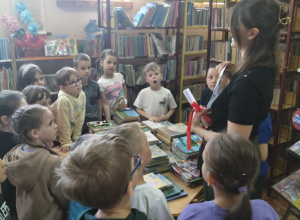 Dzieci stoją przy stole w bibliotece