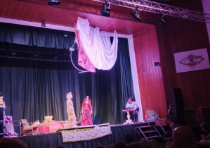 Dzieci z kółka teatralnego wraz z panią na scenie odgrywają swoje role.