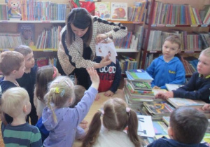 Przedszkolaki w bibliotece rozwiązują zagadki.