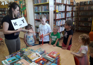 Dzieci w bibliotece poszukują zaginionych liter.