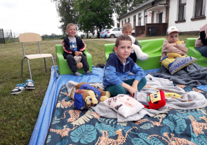 Dzieci w plenerowej strefie czytelniczej podczas akcji "Czytanie na polanie".