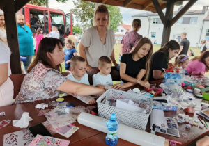 Dzieci z rodzicami podczas robienia kolorowych tatuaży.