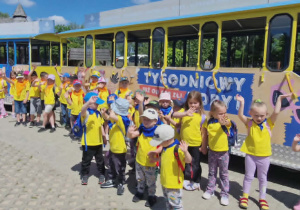 Dzieci w grupie stoją przed wagonami Zoo -kolejki