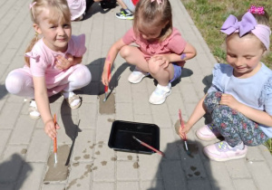 Dzieci rysują wodą na kostce