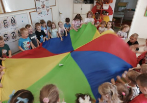 Przedszkolaki podczas zabawy z kolorową chustą.