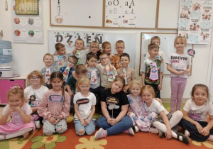 Przedszkolaki pozują do grupowego zdjęcia.
