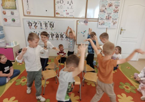 Chłopcy chodzą dookoła krzesełek podczas zabawy myzyczno-ruchowej.