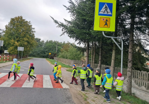 Dzieci przechodzą przez ulicę na przejściu dla pieszych