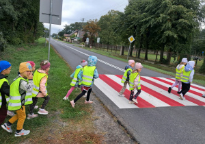 Dzieci przechodzą przez ulicę na przejściu dla pieszych
