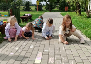 Dzieci malują kredą na kostce