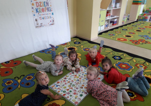 Dziewczynki na dywanie podczas zabawy: "Szukamy kropki".