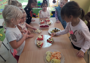 Dzieci przy stolikach komponują "Arbuzowe pizze".