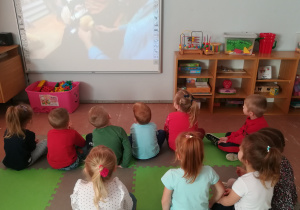 Dzieci oglądają bajkę na tablicy interaktywnej.
