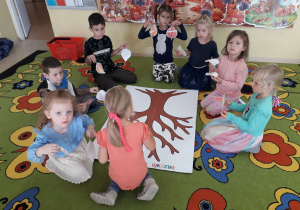 Dzieci na dywanie wykonują " Drzewo życzliwości".