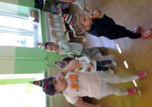 Dzieci tańczą w sali przedszkolnej.