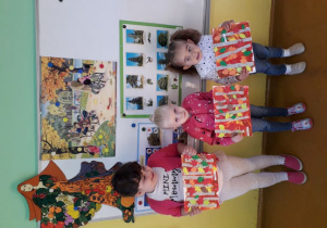 Dziewczynki prezentują swoje prace plastyczne.